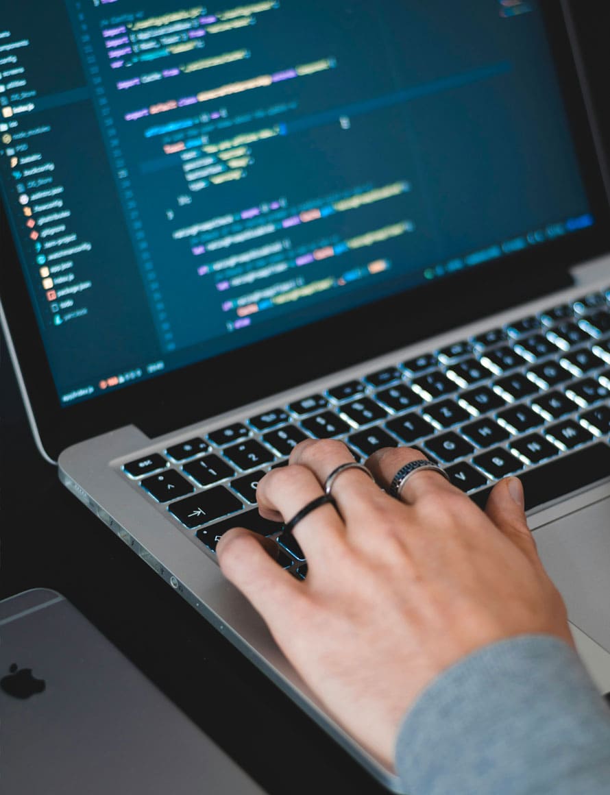 Main qui tape du code sur un ordinateur